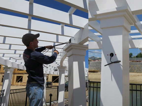 an electrician wiring lights into a pergola