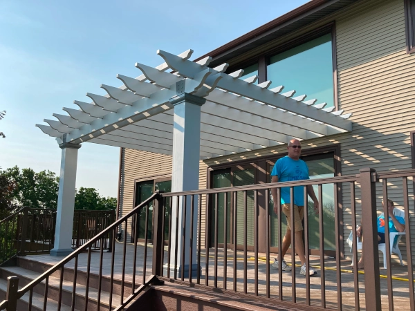 A fiberglass pergola attached to house and mounted on deck