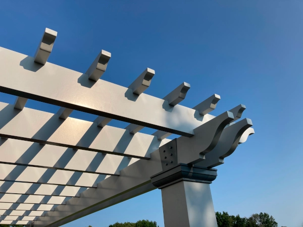 A fiberglass pergola attached to house and mounted on deck