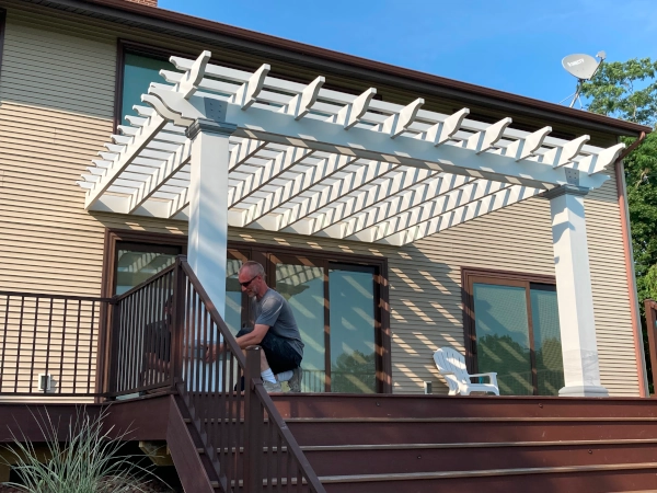 A fiberglass pergola attached to house and mounted on deck