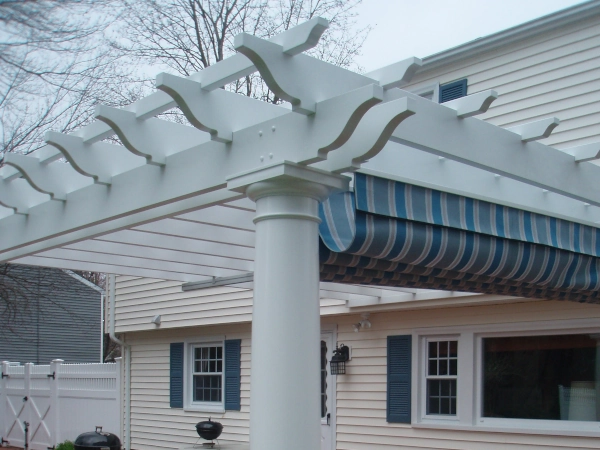 An attached fiberglass pergola with an overhead shade