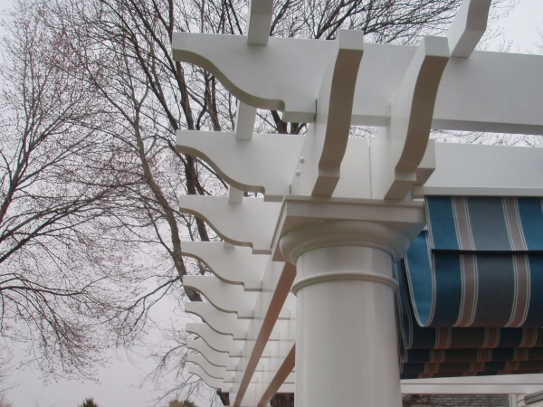 An attached fiberglass pergola with an overhead shade